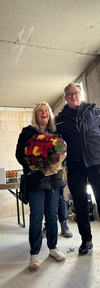 Architekt Rester un Frau mit Blumenstrauß
